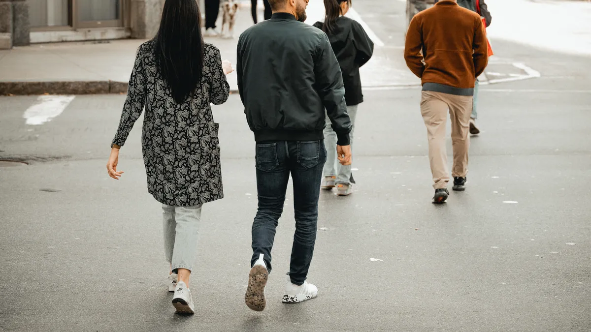 Grupo de personas caminando de espaldas por una calle