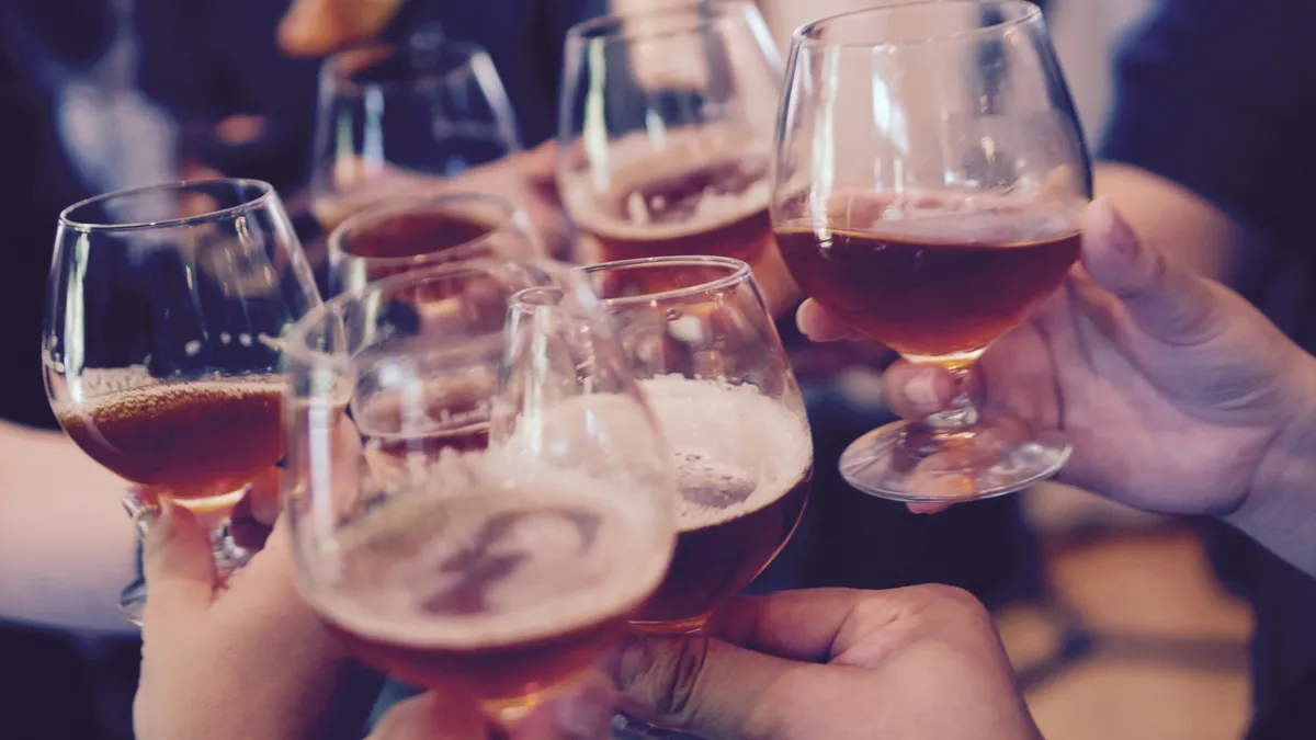 Varias personas brindando con copas de cerveza