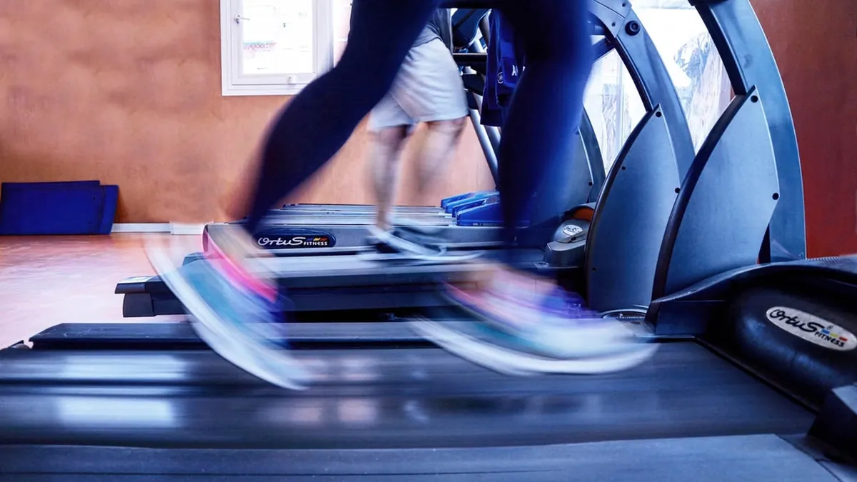 Piernas de personas corriendo en cintas en un gimnasio