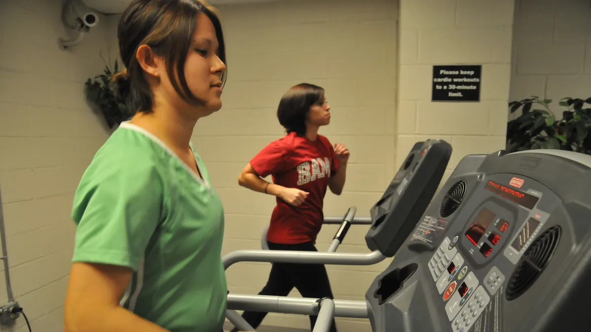 Two women walking on treadmills in a hospital gym: one 24 weeks pregnant and another who recently gave birth