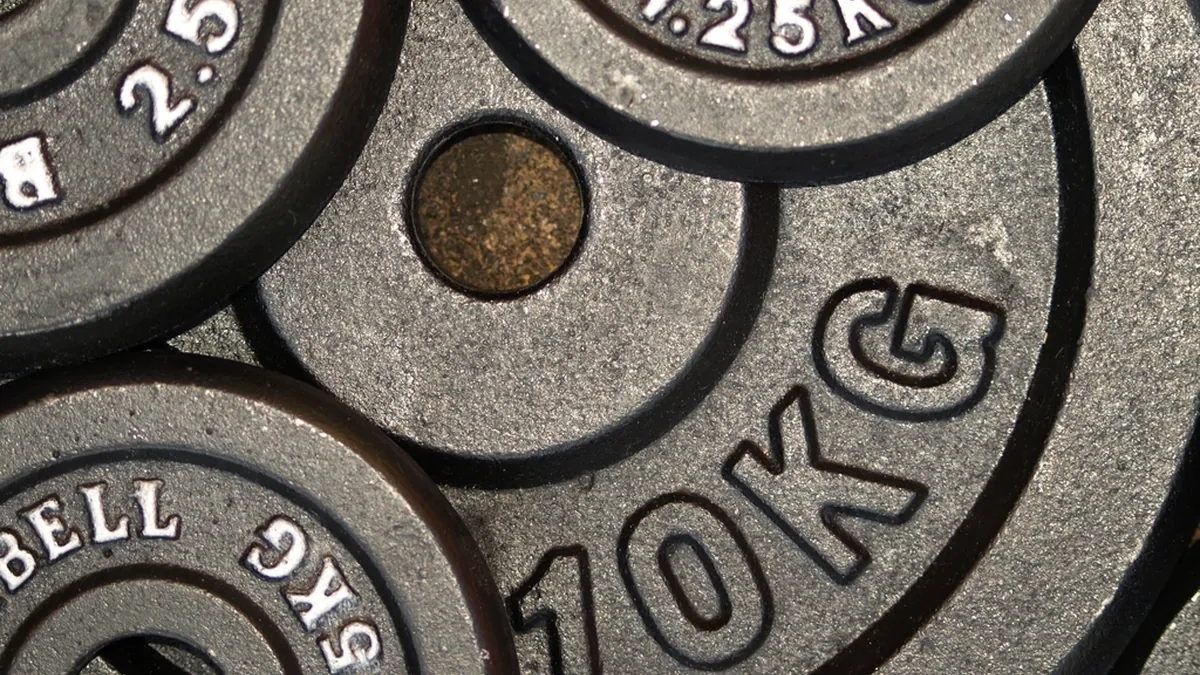 Discos de hierro de 10 kg apilados en un gimnasio
