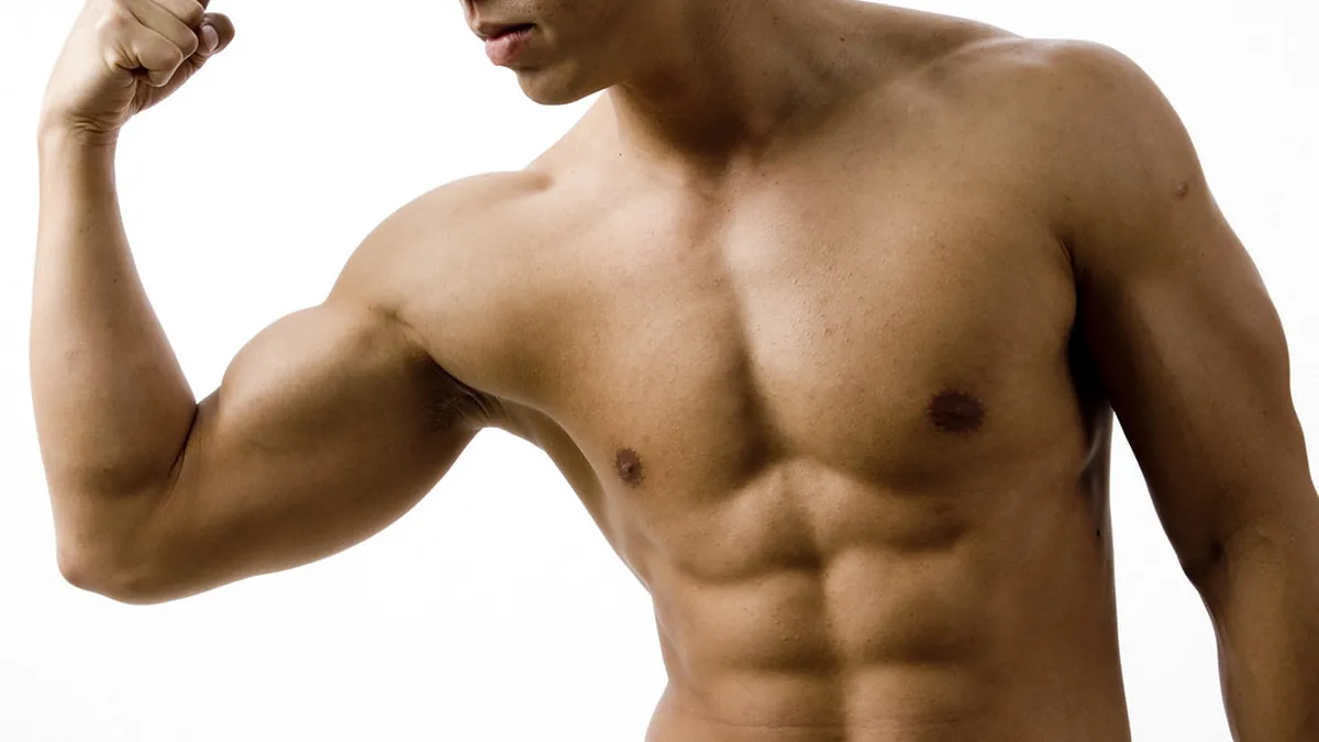 Hombre musculado sin camiseta flexionando el bíceps sobre fondo blanco