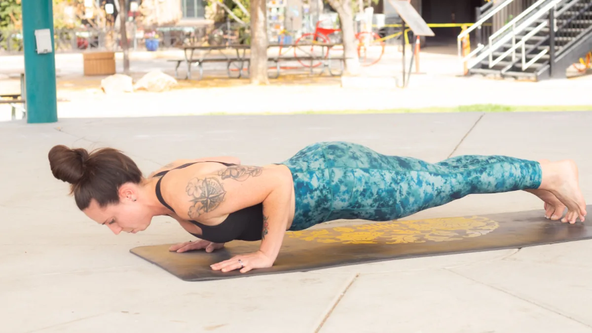 Mujer haciendo una flexión sobre una esterilla, sin material