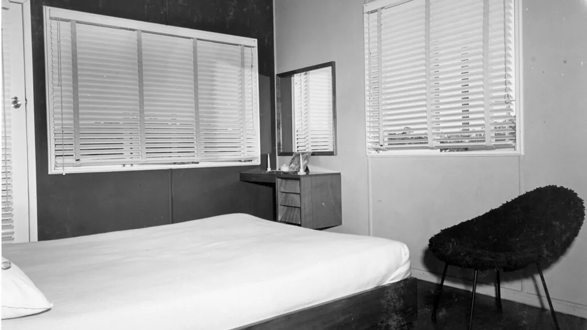 Dormitorio con la cama hecha y las persianas bajadas